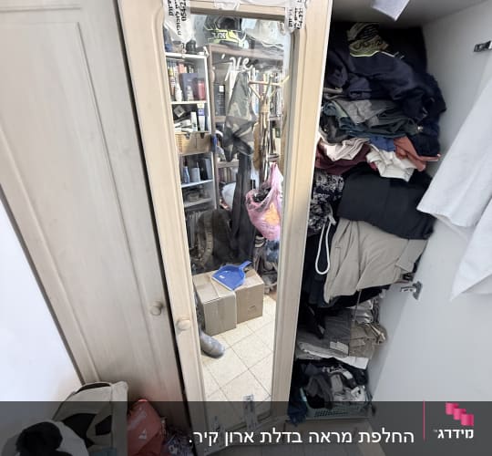 מראה בארון עם בגדים מסודרים